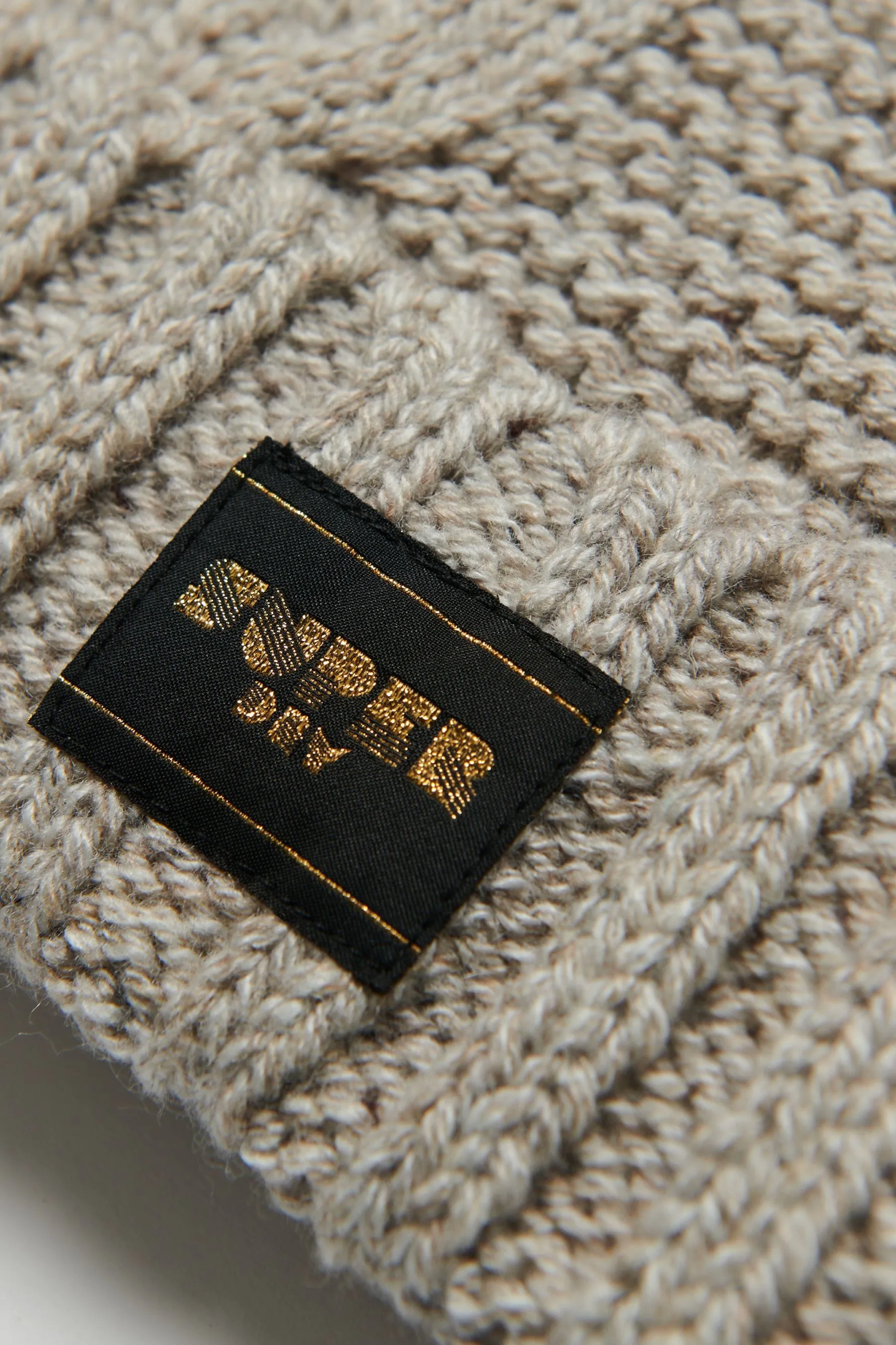 Superdry - Cappello con pompon lavorato a trecce